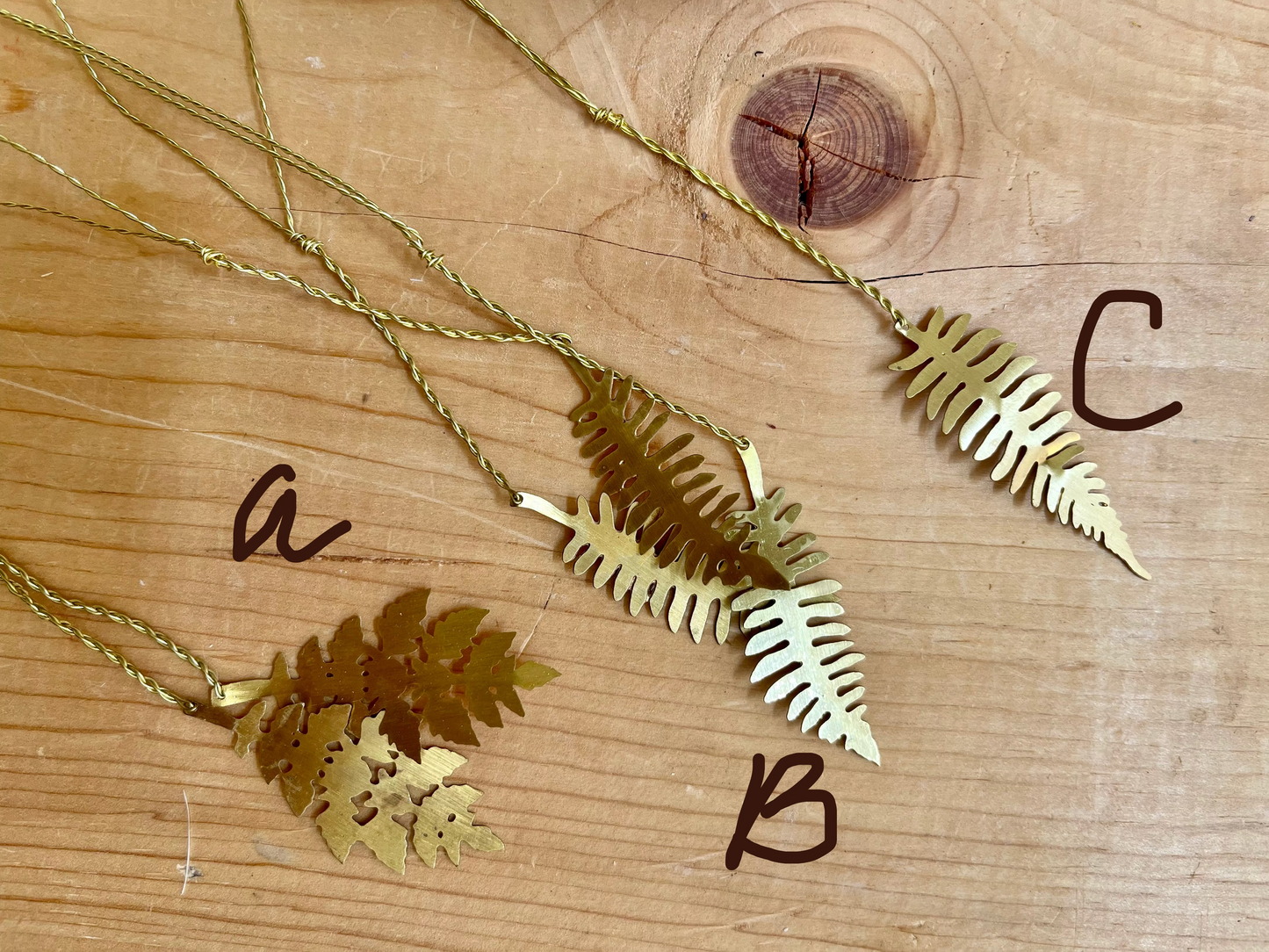 Gold leaf-shaped pendants on a wooden surface